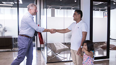 A migration agent and a client celebrating the successful approval of his visa.